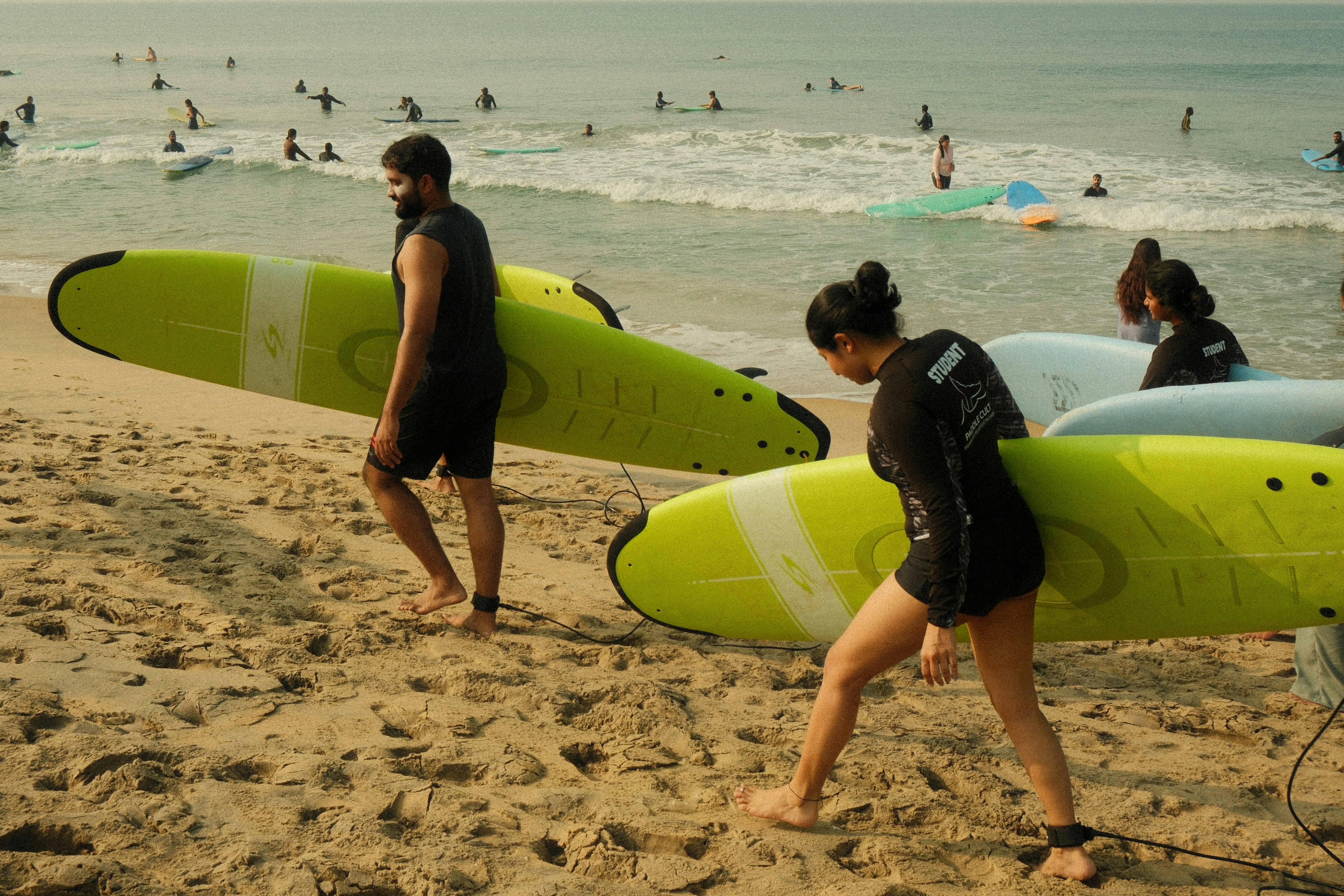 Surf lesson students carrying boards on beach in Portugal